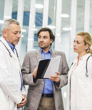 three doctors reading charts