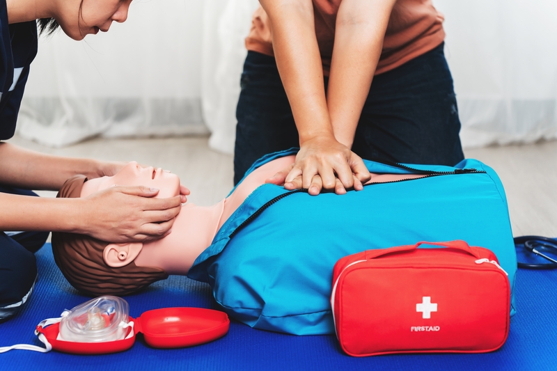 BLS training dummy used by two medical personnel to practice CPR and airway management