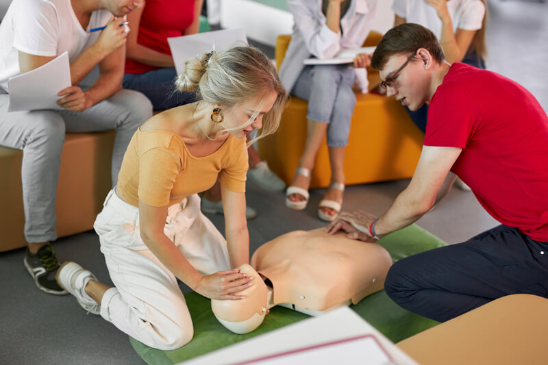 Two medical aide students in a BLS class demonstrates their BLS skills with hospital dummy