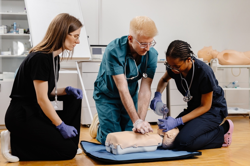 three healthcare professionals train with a dummy patient for an ACLS renewal course